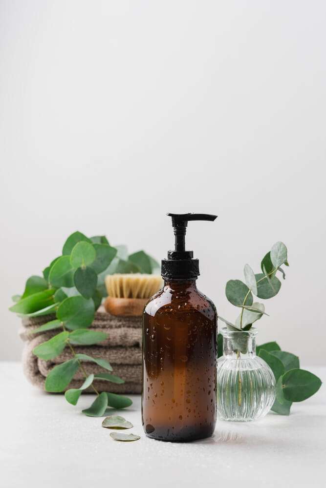 brown massage oil bottle with fresh herbs